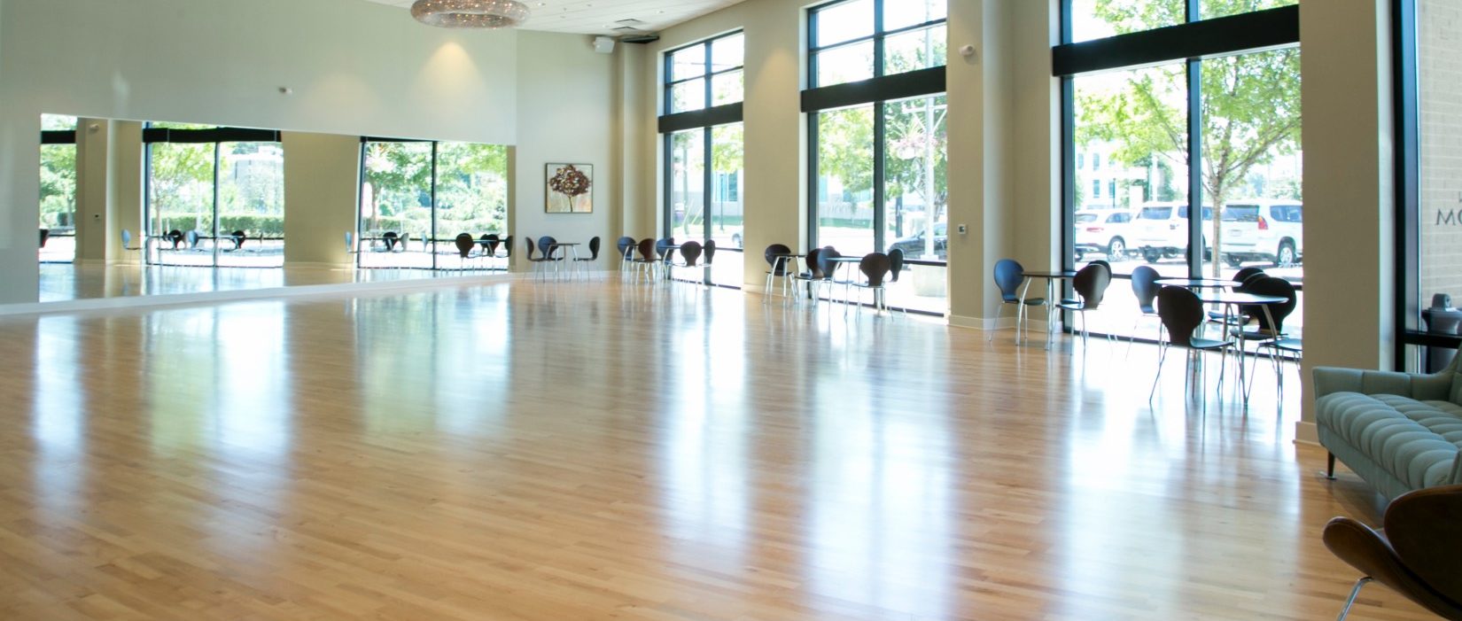 Sunlit hardwood floor and tall windows inside Midtown Ballroom